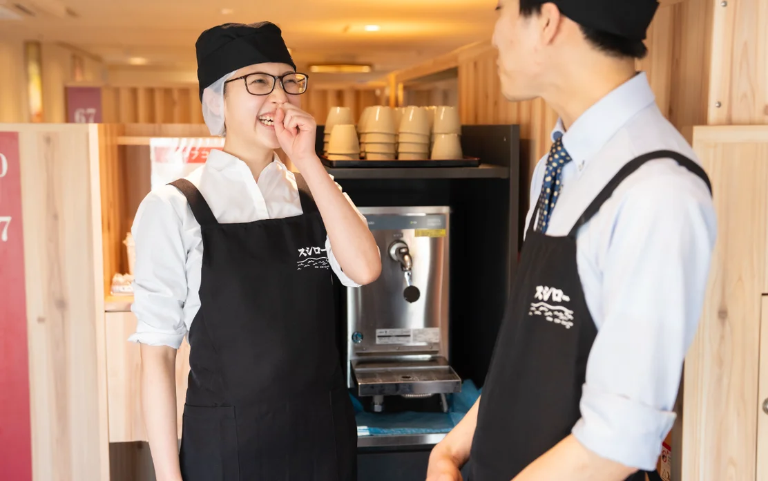 厨房で並んで作業するスシローのスタッフ